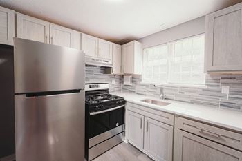 A kitchen with stainless steel appliances and white cabinets